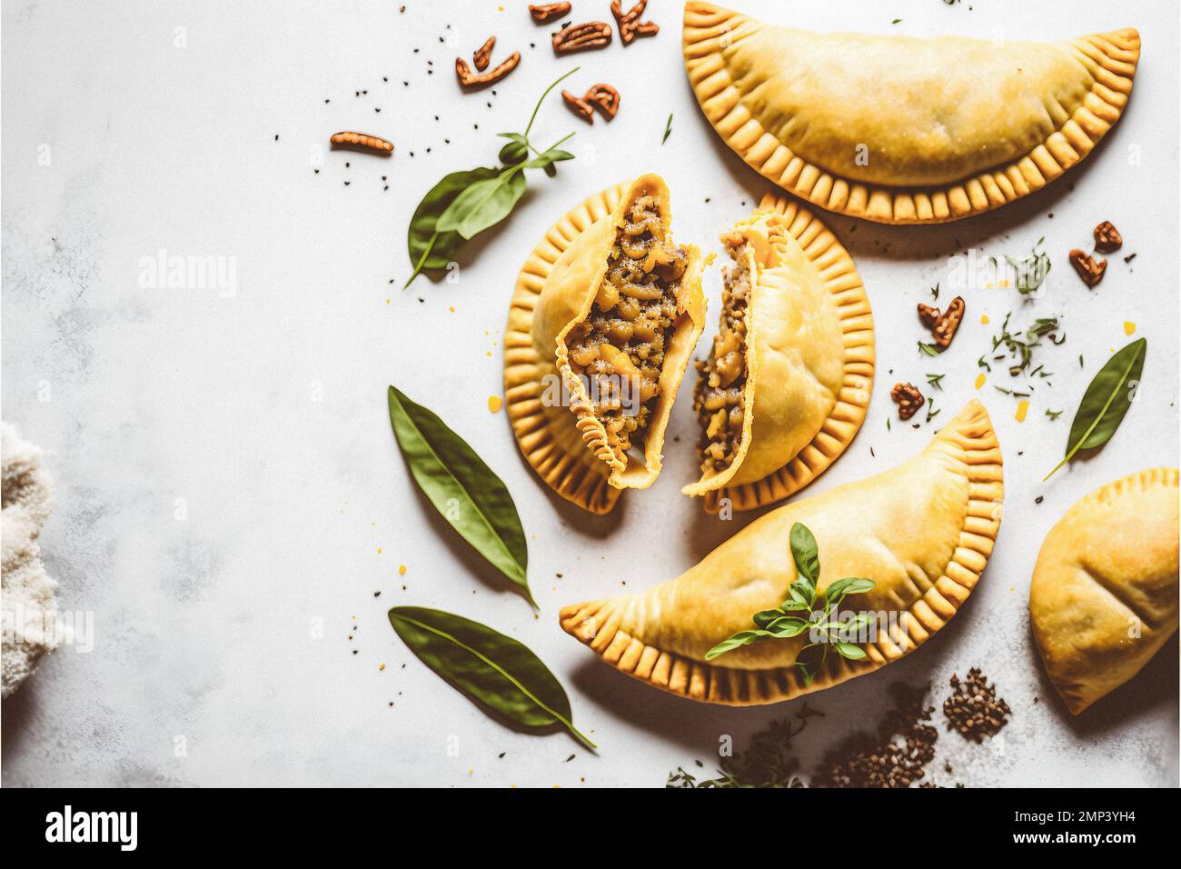 Dai un tocco di raffinatezza ai tuoi progetti alimentari con la nostra fotografia enogastronomica Empanadas su sfondo bianco. Mostra i sapori ricchi e. Foto Stock