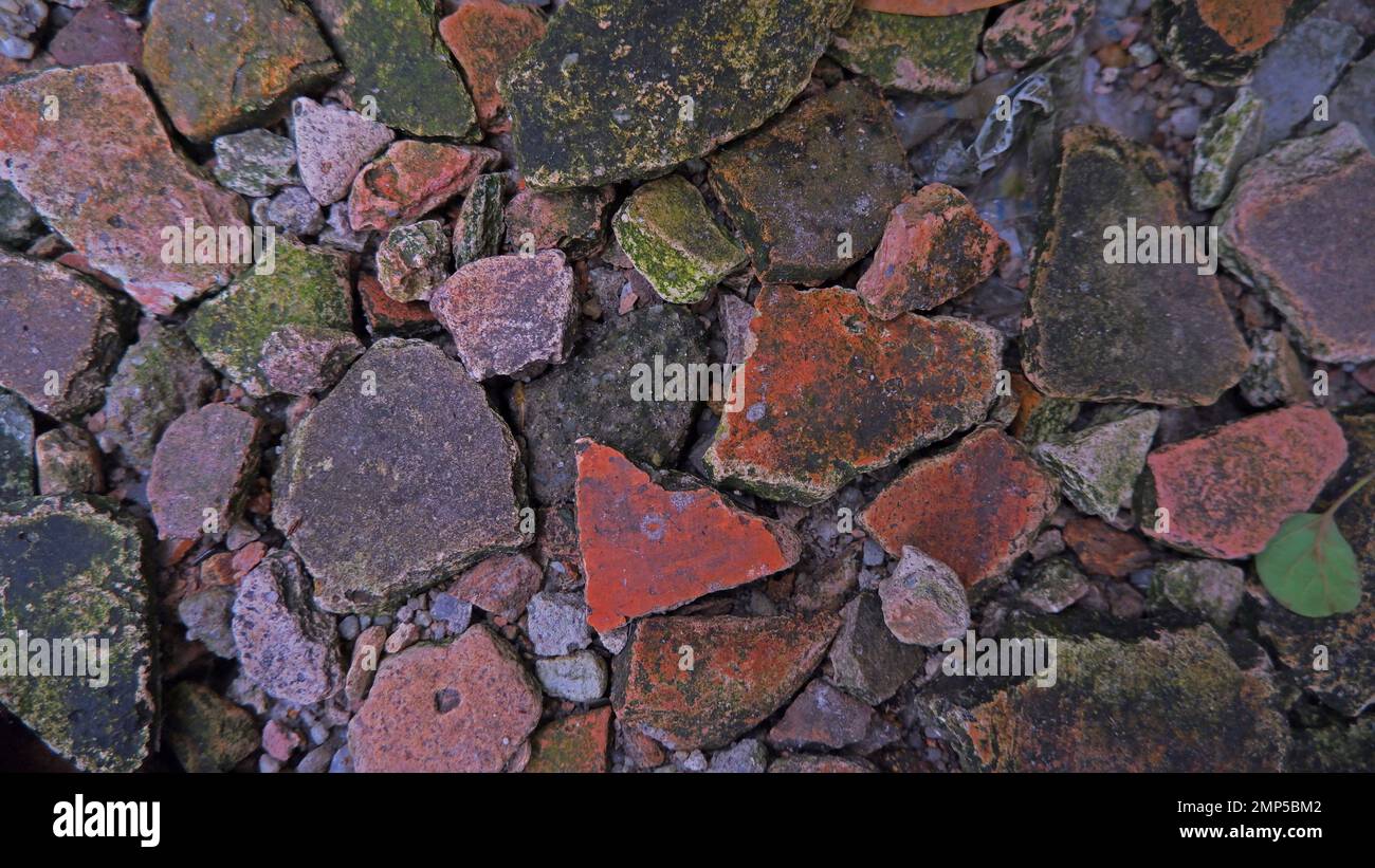 Vista ravvicinata di frammenti e frammenti di piastrelle sul tetto, che formano Una disposizione simile a un Puzzle sul terreno Foto Stock