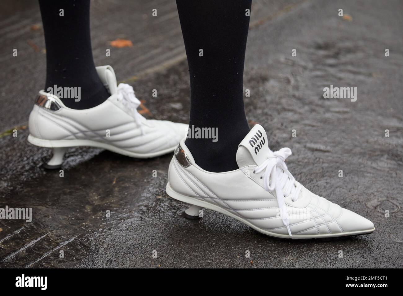 MILANO, ITALIA - 15 GENNAIO 2023: Donna con sneakers Miu Miu bianco con tacco prima della sfilata di moda Etro, Milano Fashion Week Street Style Foto Stock