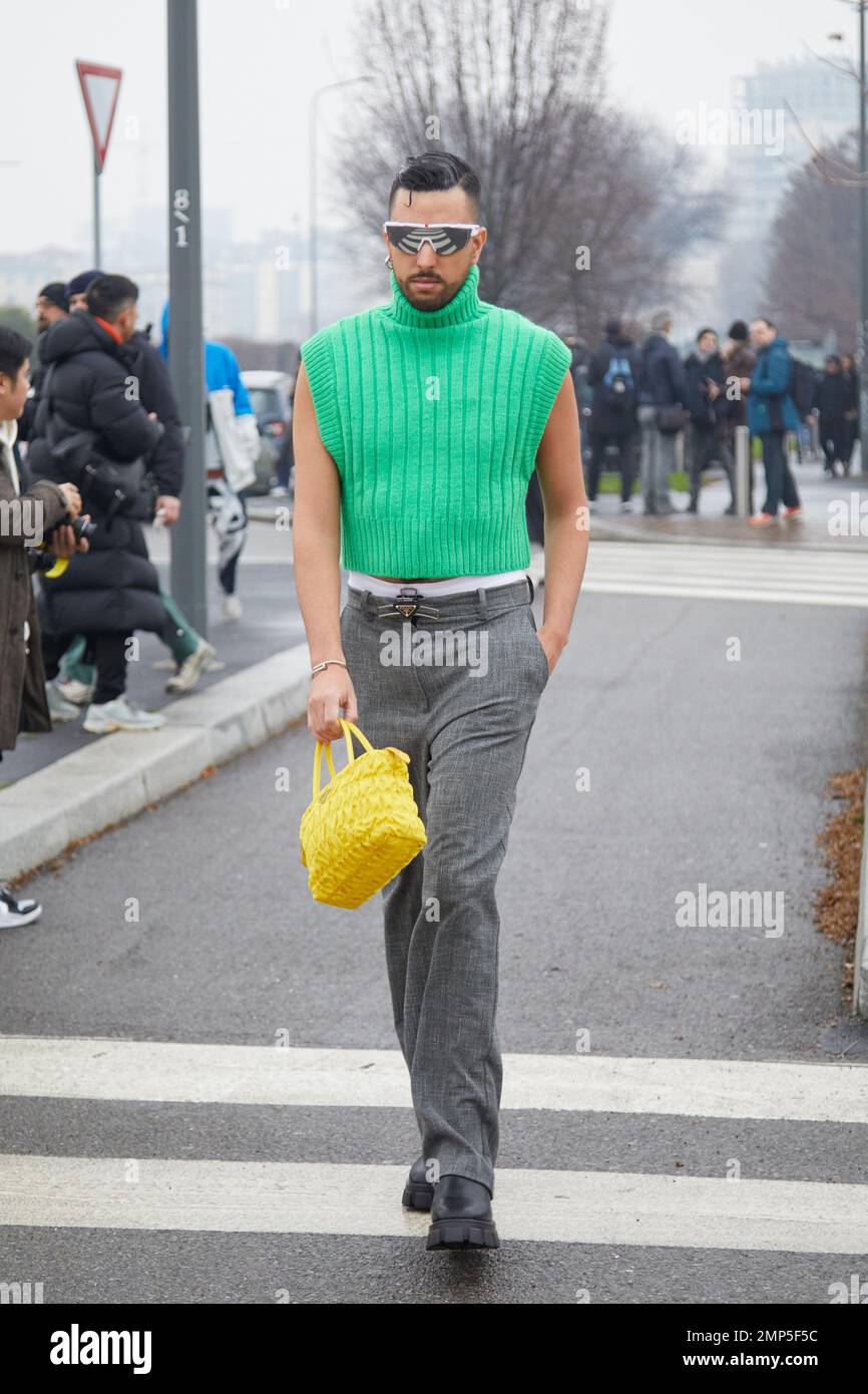 MILANO, ITALIA - 15 GENNAIO 2023: Uomo con dolcevita verde, pantaloni grigi  e borsa gialla prima della sfilata Prada, Milano Fashion Week Street Style  Foto stock - Alamy