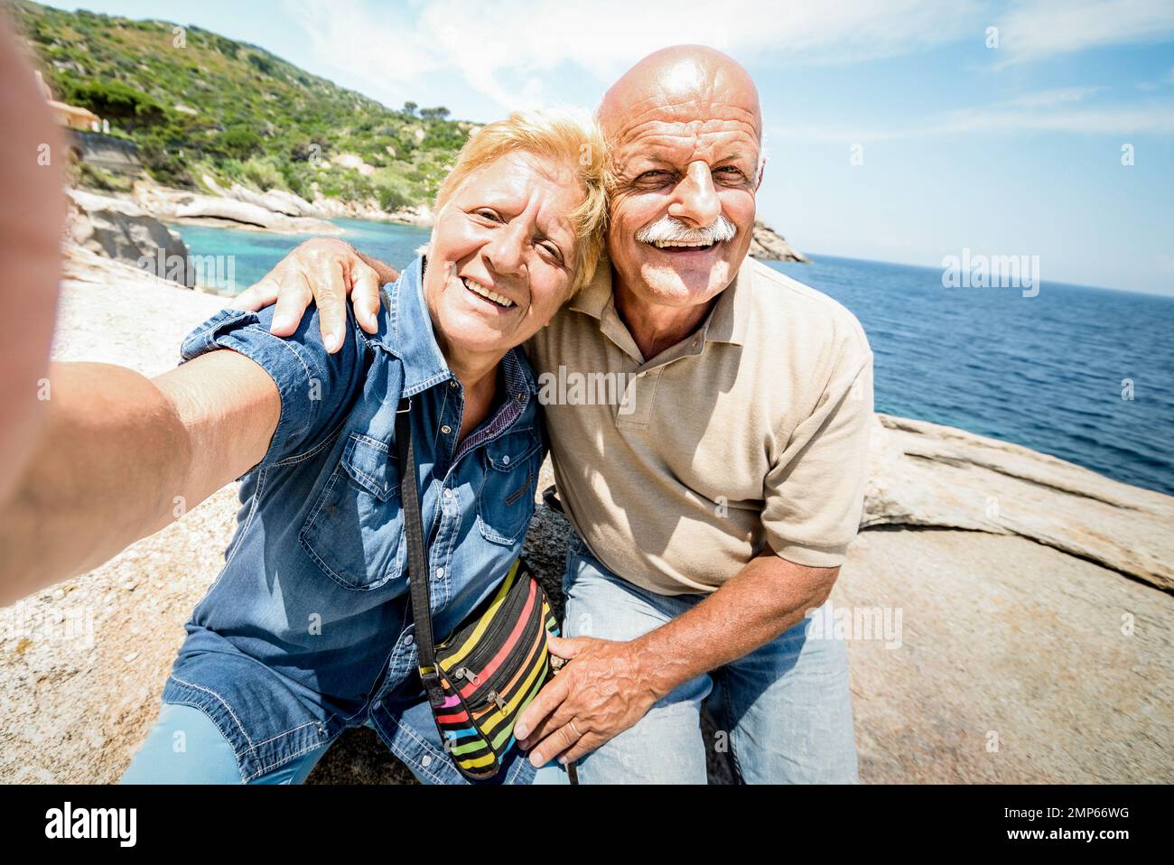 Coppia anziana vacanziera che prende selfie mentre si diverte genuino all'Isola del Giglio - escursione in scenario di mare - concetto anziano attivo Foto Stock