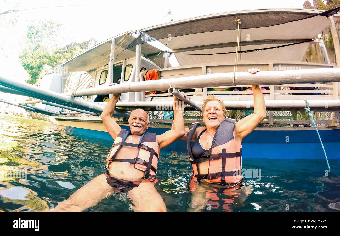 Coppia anziana vacanziera che ha divertimento genuino giocoso alla spiaggia nelle Filippine - gita in barca di snorkeling in scenario esotico - anziano attivo e concetto di viaggio Foto Stock