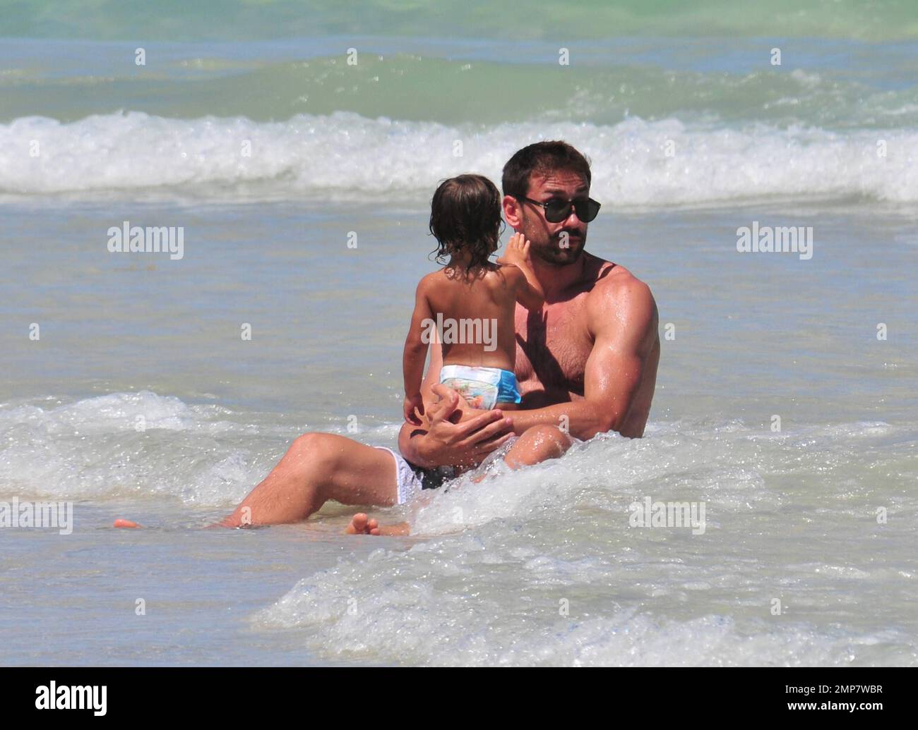Adriana Lima, la figlia Valentina e il marito Marko Jaric si divertono nel surf a Miami Beach, Florida, 31st luglio 2011. Foto Stock