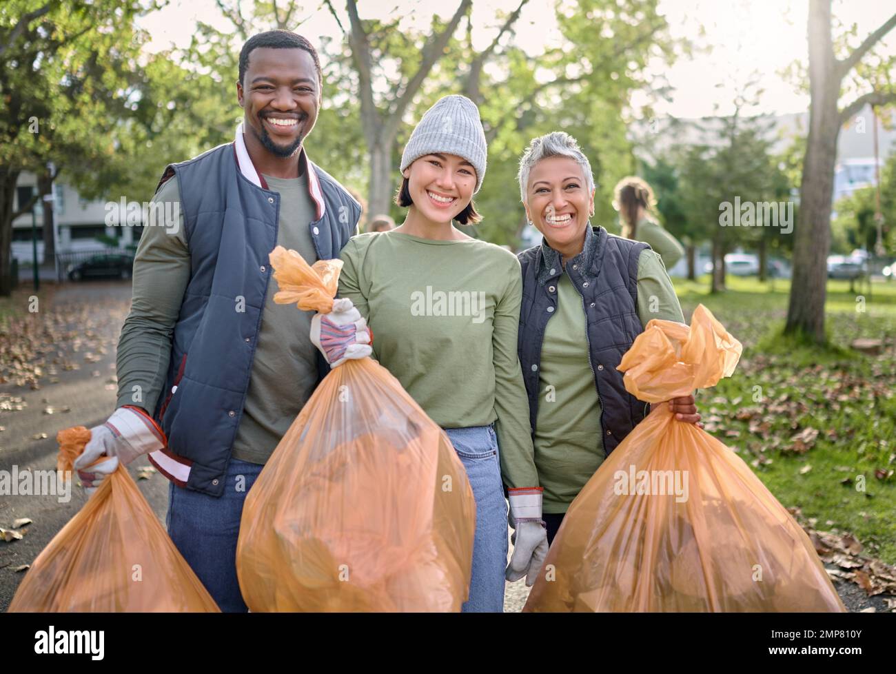 Uomini volontari e donne puliscono il parco come servizio di comunità con plastica in sacchetto di rifiuti. Gruppo diversità aiutare con rifiuti per uno stile di vita ecocompatibile e. Foto Stock
