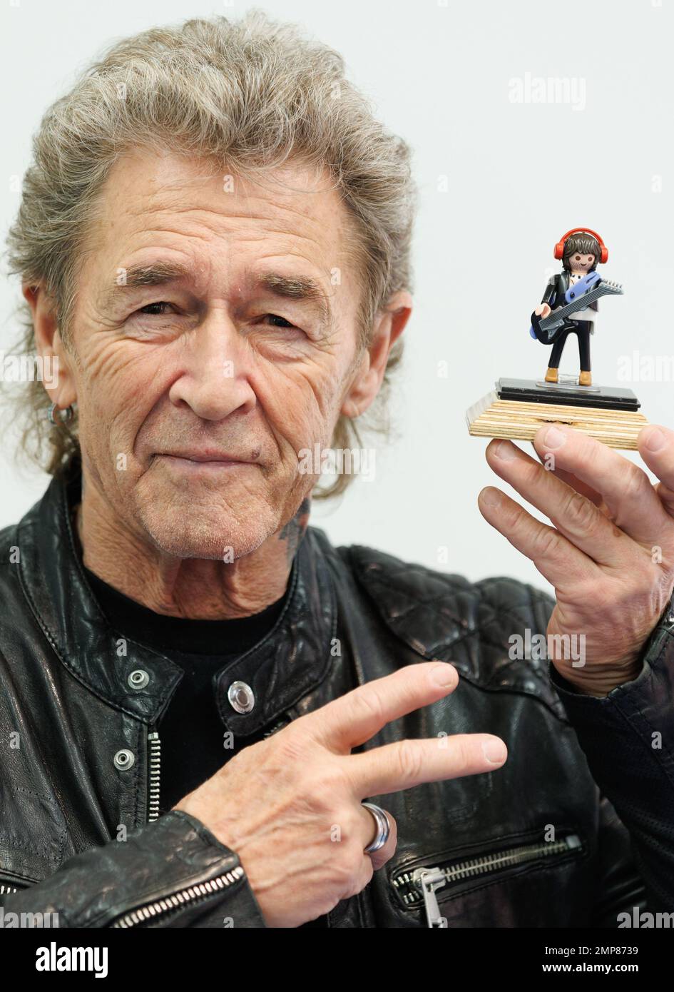 Norimberga, Germania. 31st Jan, 2023. Peter Maffay, musicista, tiene in mano una figurina con la sua somiglianza allo stand Playmobil ai margini dello spettacolo di novità Spielwarenmesse. Il 72nd Spielwarenmesse si svolge dal 1 al 5 febbraio 2023. Credit: Daniel Karmann/dpa/Alamy Live News Foto Stock