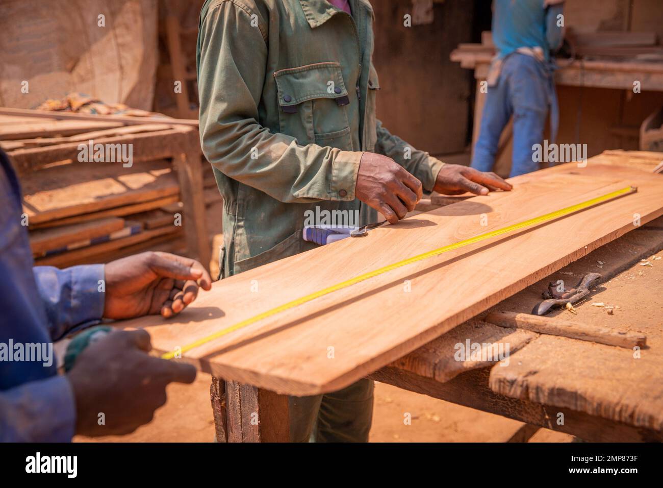 Primo piano delle mani dei falegnami che effettuano le misurazioni di una tavola di legno, lavori di carpenteria Foto Stock