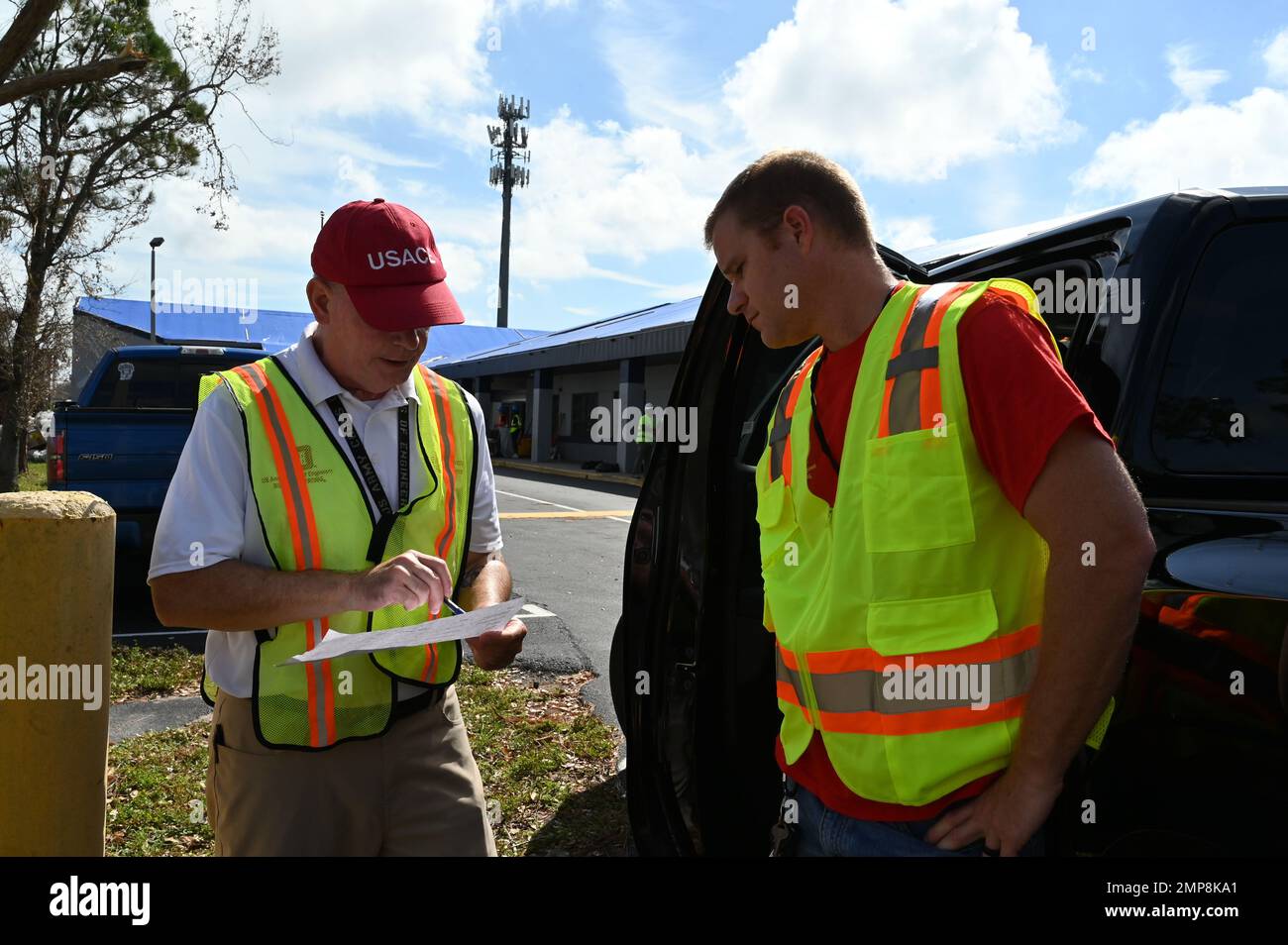 Il corpo dell'esercito degli Stati Uniti dei dipendenti degli ingegneri Allen Roos, a sinistra, e Tom Spencer, discute una valutazione del luogo di un'infrastruttura critica in una scuola pubblica a Fort Myers, Florida, ottobre 11. Attualmente ci sono più di 280 dipendenti USACE dislocati in Florida che stanno sostenendo attivamente la FEMA e le operazioni di recupero dello stato. Foto Stock