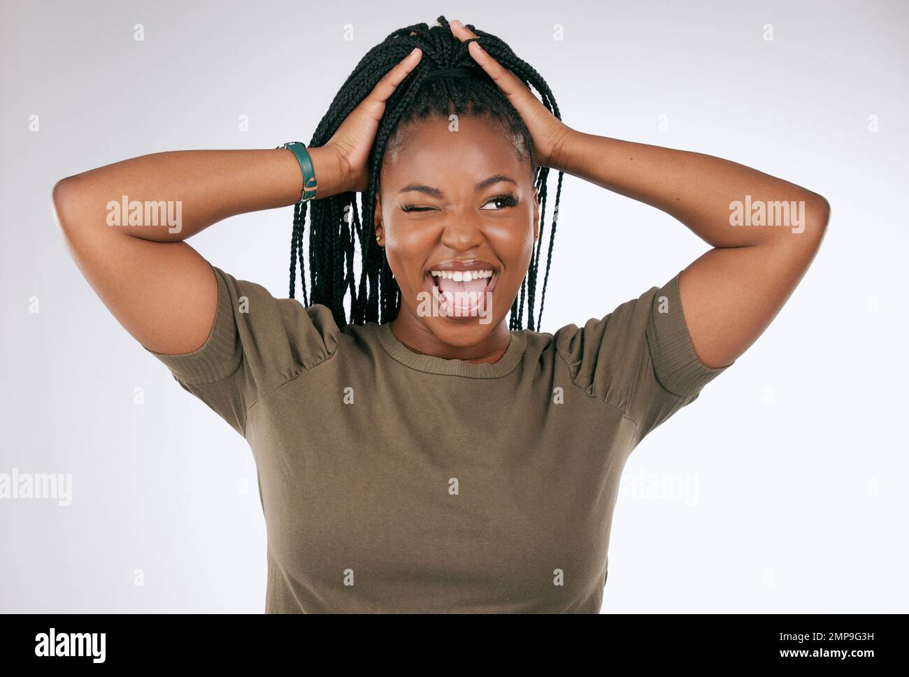 Donna comica, divertente e nera con un volto pazzo isolato su uno sfondo grigio studio. Sorriso, felice e ragazza africana modello con lingua che si stacca per Foto Stock