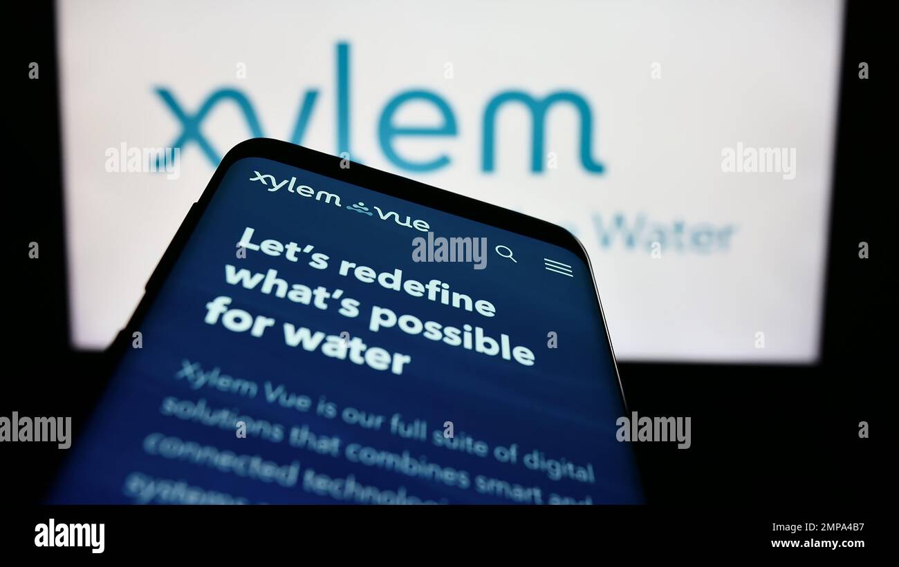 Telefono cellulare con sito web della società di tecnologia idrica statunitense Xylem Inc. Sullo schermo di fronte al logo aziendale. Messa a fuoco in alto a sinistra del display del telefono. Foto Stock