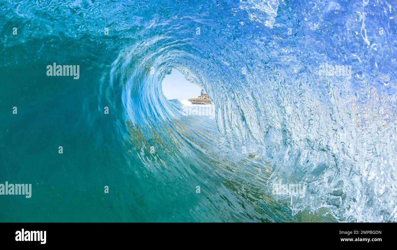 Surf da onda in tube con vista all'interno di una cava che si schiantava con acqua blu e nuoto foto Foto Stock