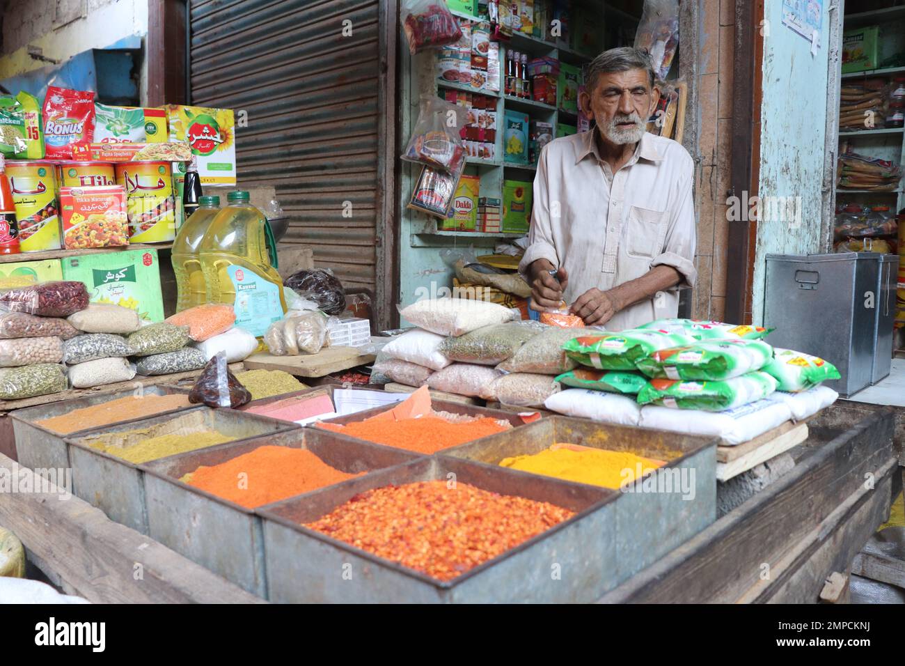 karachi Pakistan 2019, un negoziante seduto nel suo negozio di masala al mercato di Kharadar la mattina presto, venditori locali di karachi Foto Stock