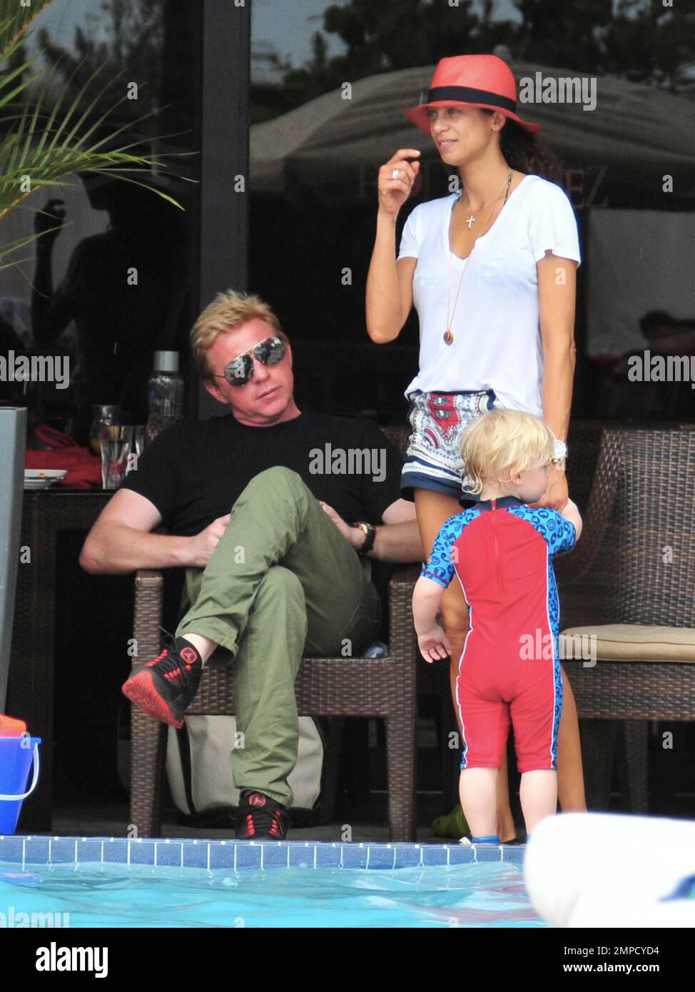 Boris Becker e sua moglie Lily sono stati visti godendo mojitos mentre si rilassavano in piscina con gli amici in un hotel a South Beach. Dopo aver trascorso diversi giorni sotto il sole di Miami, Boris sembrava un po' rosso sul viso, segni di una possibile scottatura del sole. Lily indossava un cappello color salmone con una parte superiore bianca e pantaloncini con motivi floreali sopra il bikini. Il figlio adorabile Amadeus di 2 anni è stato visto giocare in piscina mentre la mamma lo guardava. Ad un certo punto Lily ha letto un libro ad Amadeus mentre si è seduto sul suo grembo. Miami, Florida. 6th aprile 2012. . Foto Stock