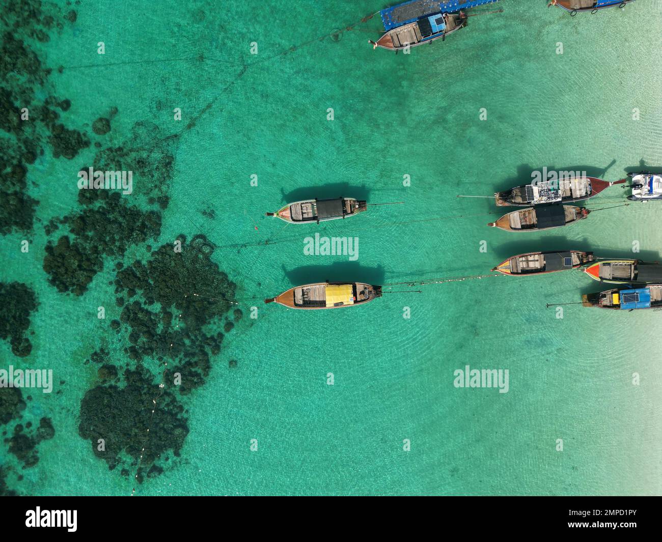 Una rilassante scena aerea con cinque barche ancorate su una spiaggia vicino a un po 'di acqua calma Foto Stock