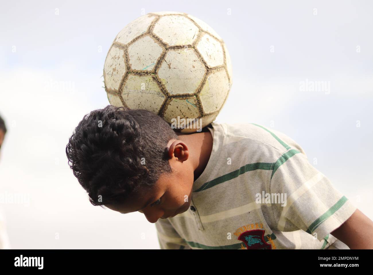 Karachi Pakistan 2019, un bambino in posa per la foto con il suo calcio blu la domenica mattina nel campo di calcio, bambini asiatici, sport locali, calcio in pa Foto Stock