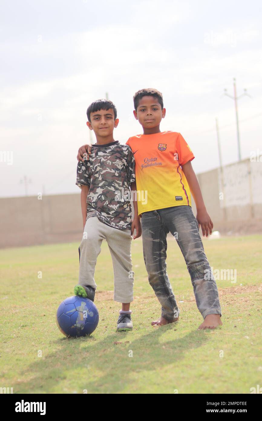 Karachi Pakistan 2019, un bambino in posa per la foto con il suo calcio blu la domenica mattina nel campo di calcio, bambini asiatici, sport locali, calcio in pa Foto Stock