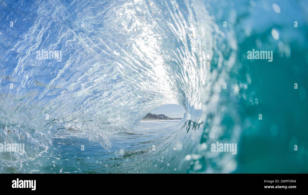 Surf da onda in tube con vista all'interno di una cava che si schiantava con acqua blu e nuoto foto Foto Stock