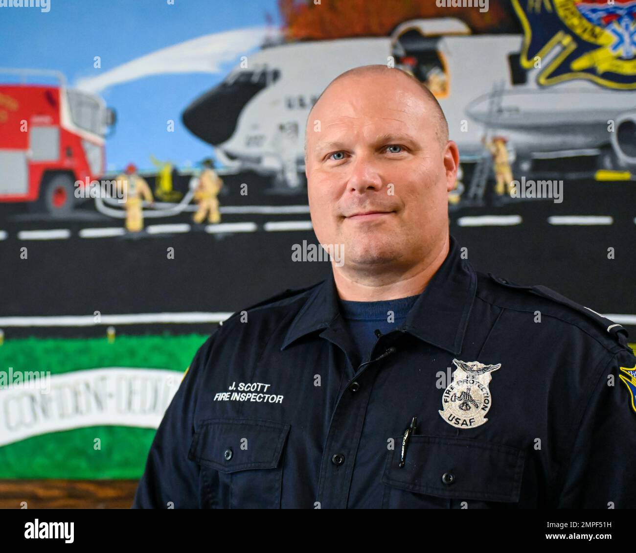 Jay Scott, un ispettore antincendio assegnato al 6th ingegneria civile pose Squadron con un murale che dipinse alla base dell'aeronautica militare di MacDill, Florida, 13 ottobre 2022. Il murale raffigura vigili del fuoco che rispondono ad un fuoco di Stratotanker KC-135 su una linea di luce. Recentemente, Scott ha completato due murales su larga scala alla stazione dei vigili del fuoco 1 insieme ad un certo numero di schizzi dettagliati che ha regalato ai colleghi. Foto Stock