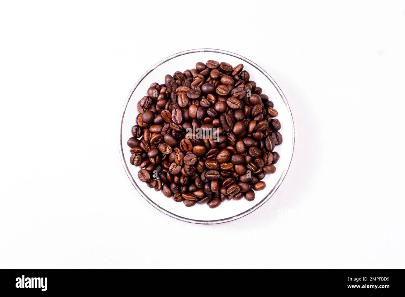 Vista dall'alto Di Un piattino pieno di fagioli isolati su una superficie bianca Foto Stock