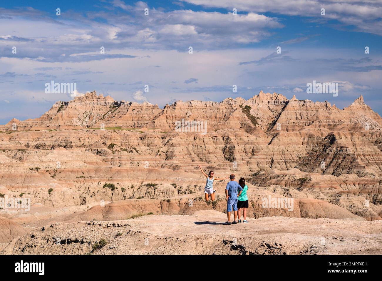 La famiglia fotografa la figlia che salta al White River Valley nel Badlands National Park, South Dakota. Foto Stock