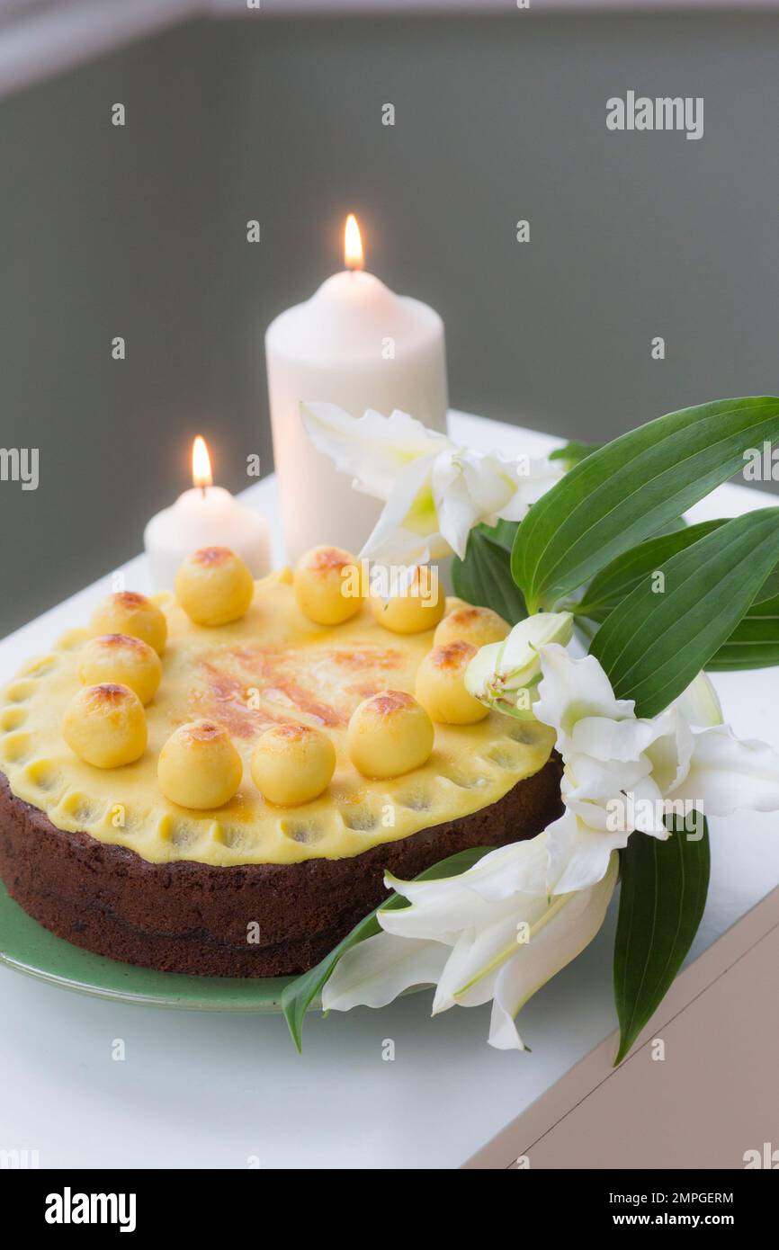 Tavolo di Pasqua con torta Simnel e candele accese Foto Stock