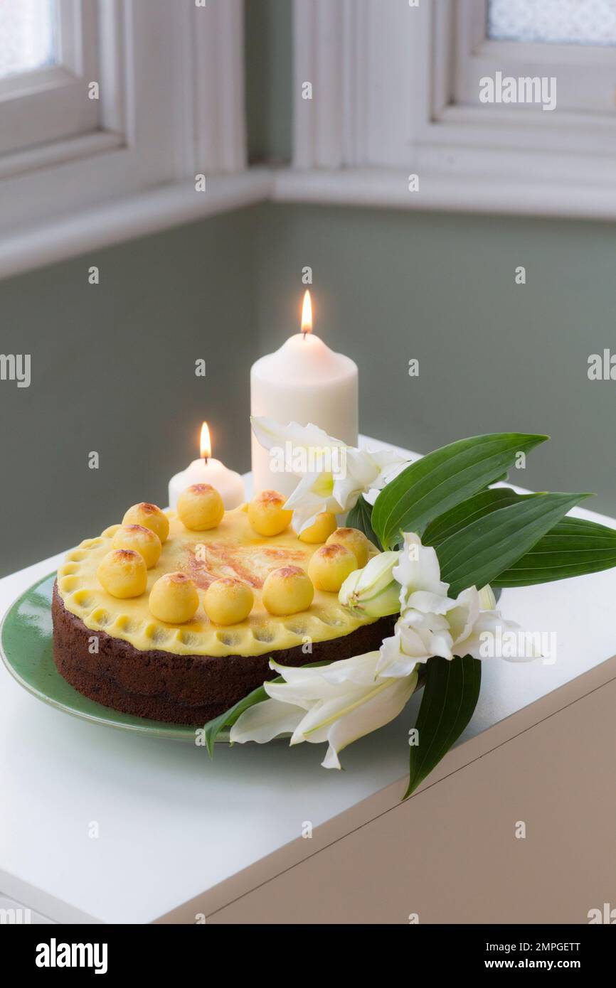 Tavolo di Pasqua con torta Simnel e candele accese Foto Stock