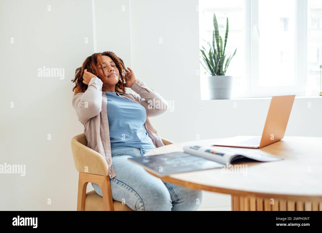 Una giovane afroamericana sta lavorando su un computer portatile. Una studentessa focalizzata sta guardando lo schermo del computer e guardando il webinar o facendo videochat Foto Stock