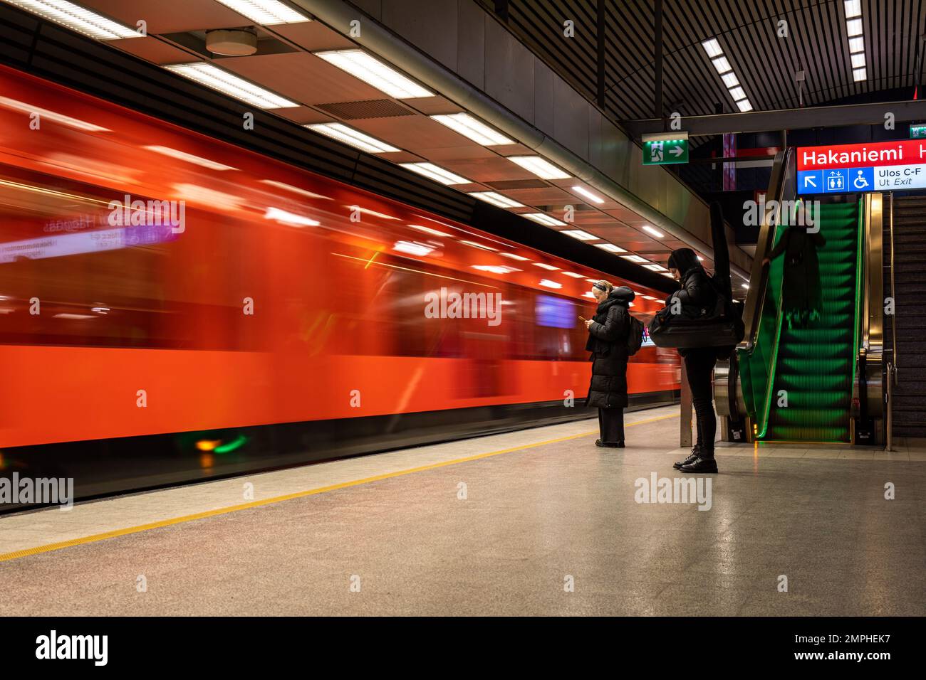 Movimento sfocato su un treno arancione della metropolitana nella stazione di Hakaniemi a Helsinki, Finlandia Foto Stock