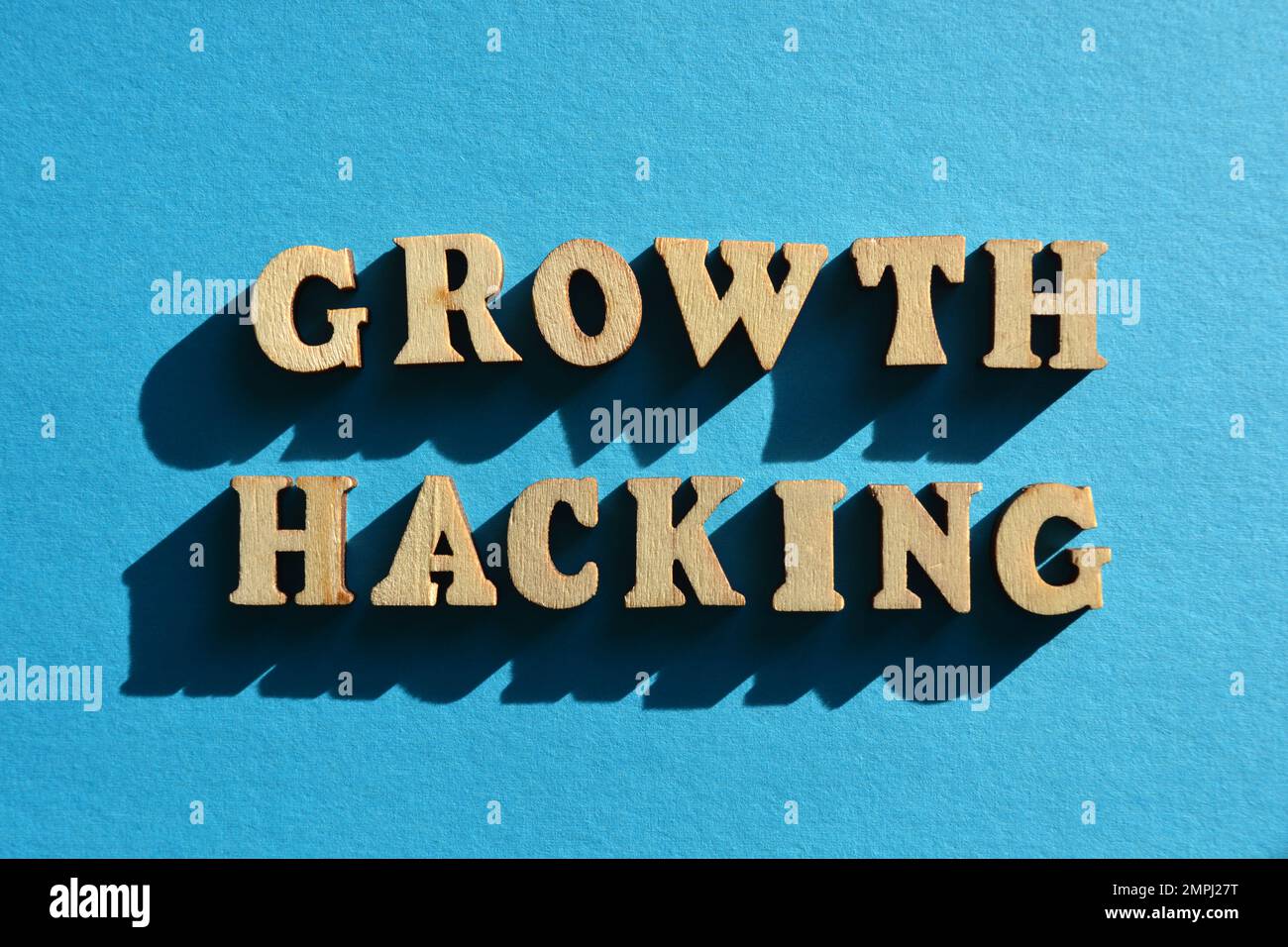 Growth Hacking, parole in alfabeto di legno etters isolato su sfondo blu Foto Stock