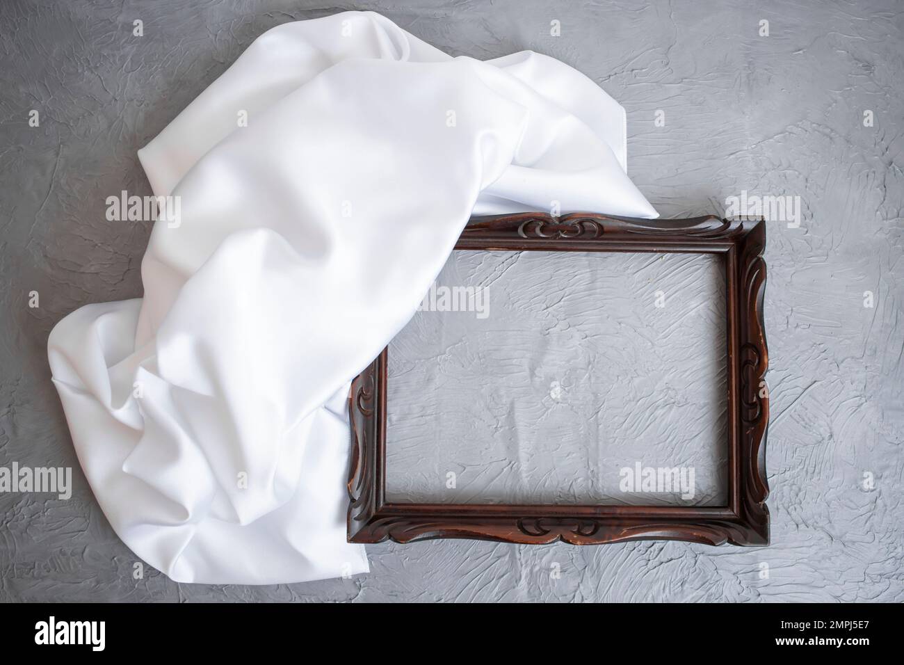 Cornice marrone in cemento grigio con tela satinata bianca, realizzata per la presentazione del prodotto Foto Stock