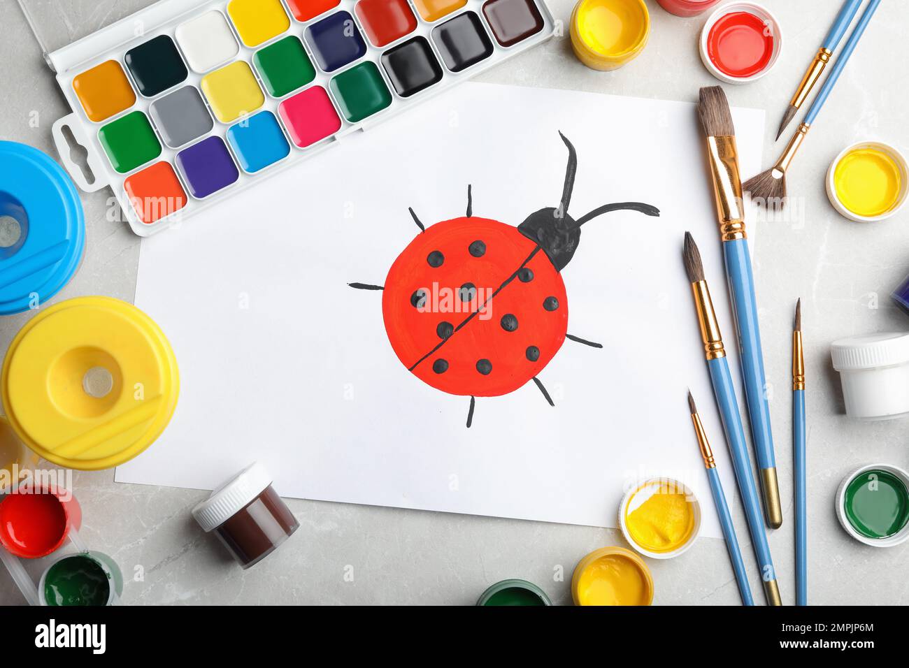 Composizione di posa piatta con pittura di coccinella su tavolo in marmo per bambini Foto Stock