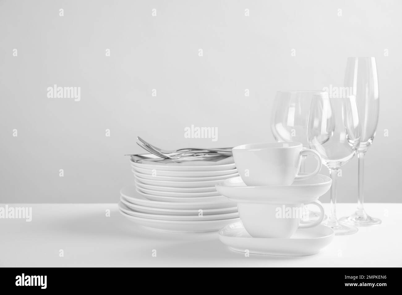 Set di piatti puliti su tavolo bianco Foto Stock