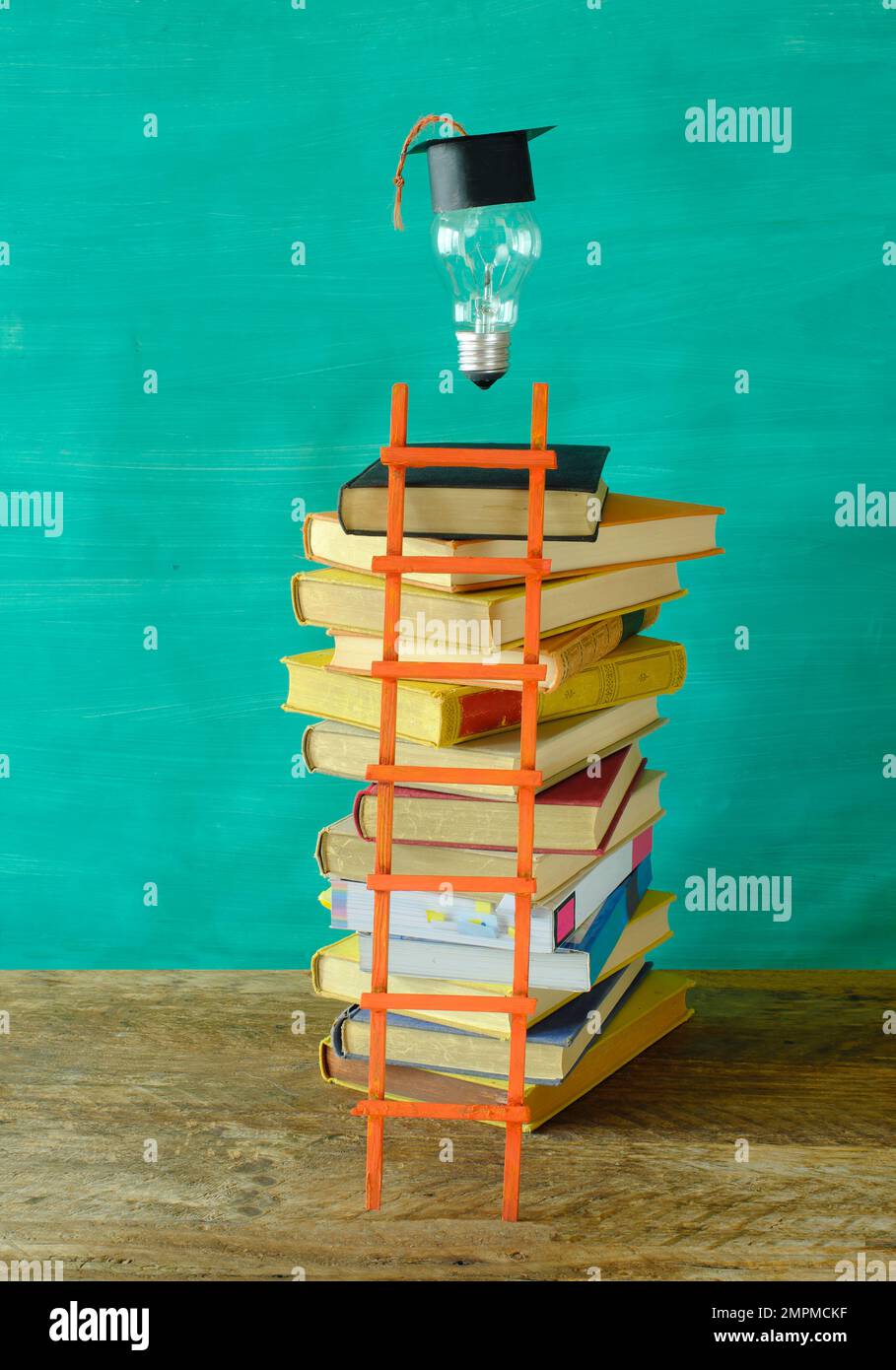 Pila di libri con dorso rigido con cappello e lampadina. Apprendimento, educazione, sviluppo personale, scala di successo e concetto di ritorno a scuola. Foto Stock