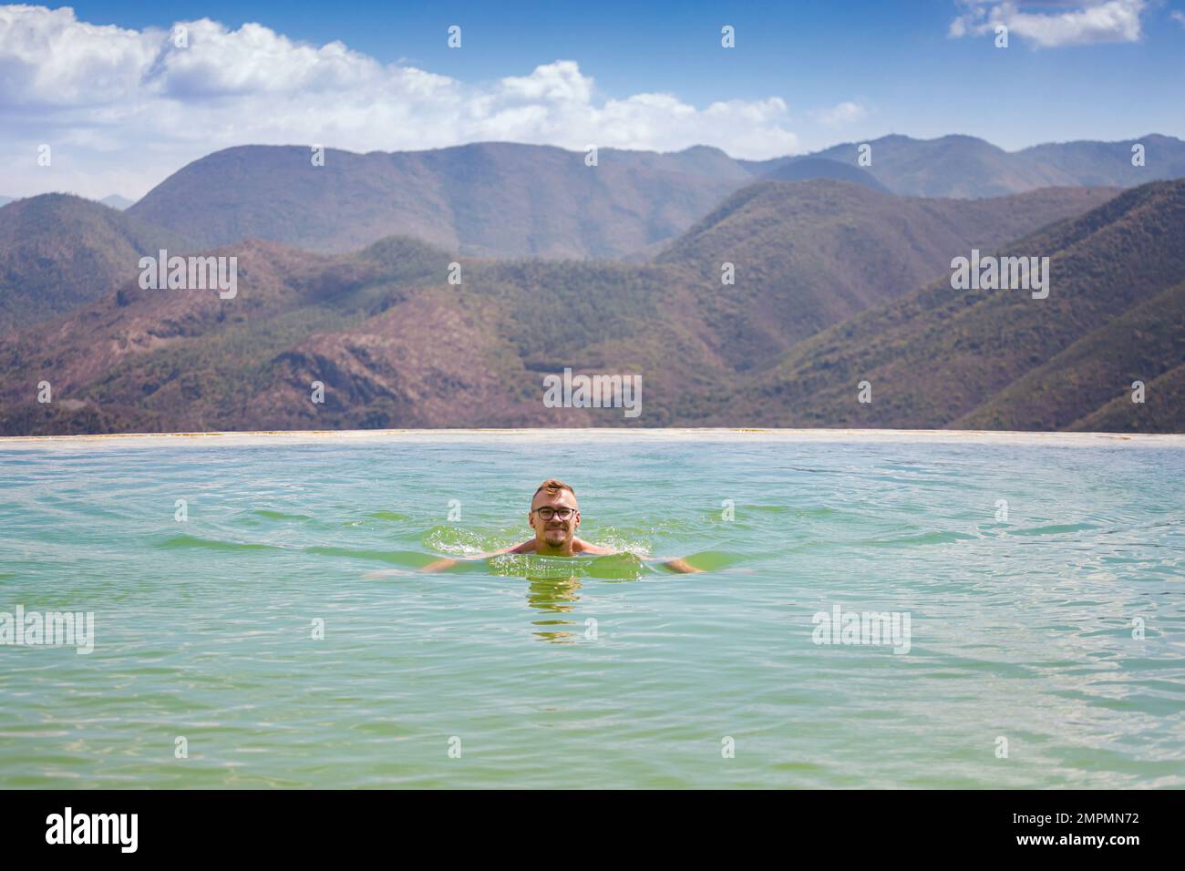 Bellissimo paesaggio di piscina naturale a sfioro Hierve el Agua con giovane uomo caucasico rilassante, cascate Oaxaca, Messico Foto Stock