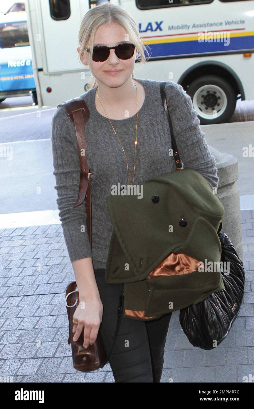 Oscar nominata film, 'Hugo,' attrice Chloe Grace Moretz in un maglione  grigio, pantaloni neri, stivali neri e con un cappotto verde è stato visto  in partenza da Los Angeles International Airport prima