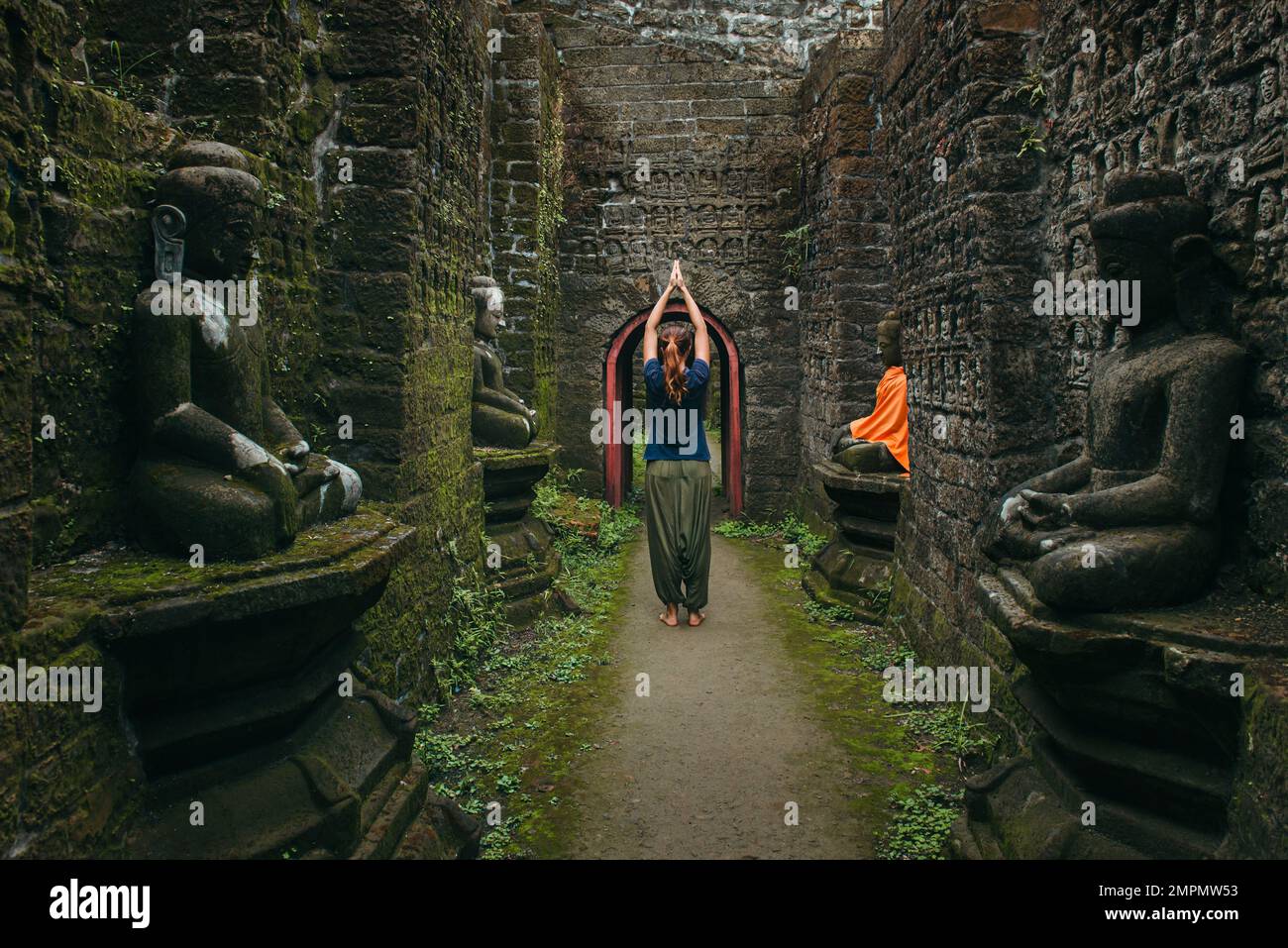 Viaggio spirituale in Myanmar. Donna in meditazione posa con mani sollevate rimanere nel tempio buddista Foto Stock