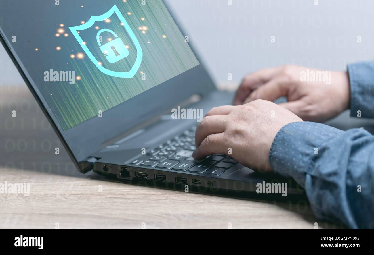 Concetti sulla sicurezza online. uomo che entra nel sistema di sicurezza tramite computer portatile. Gli schermi dei notebook sono crittografati, il furto di dati da parte di hacker, antivirus, furto di identità. Foto Stock