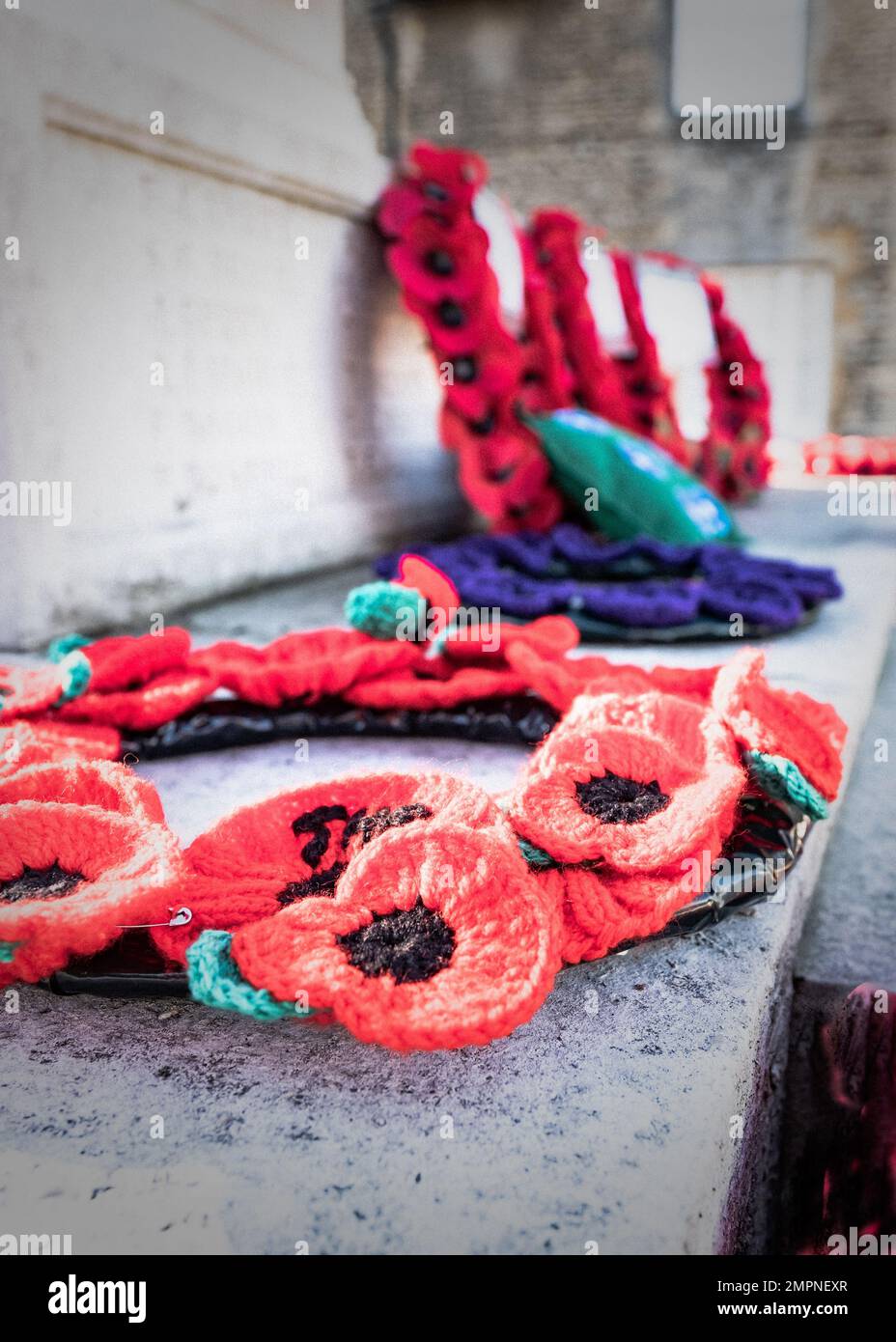 Un colpo verticale di corone papavero del giorno della memoria posato sul memoriale di guerra a Witney, Oxfordshire Foto Stock
