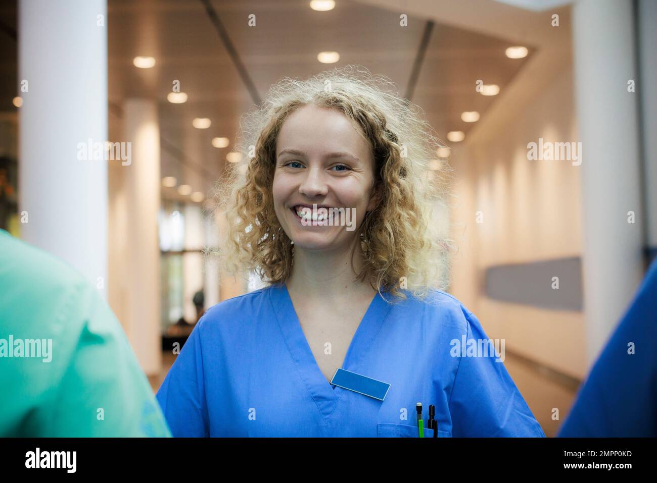 Ritratto di felice infermiera femminile con capelli biondi in ospedale Foto Stock