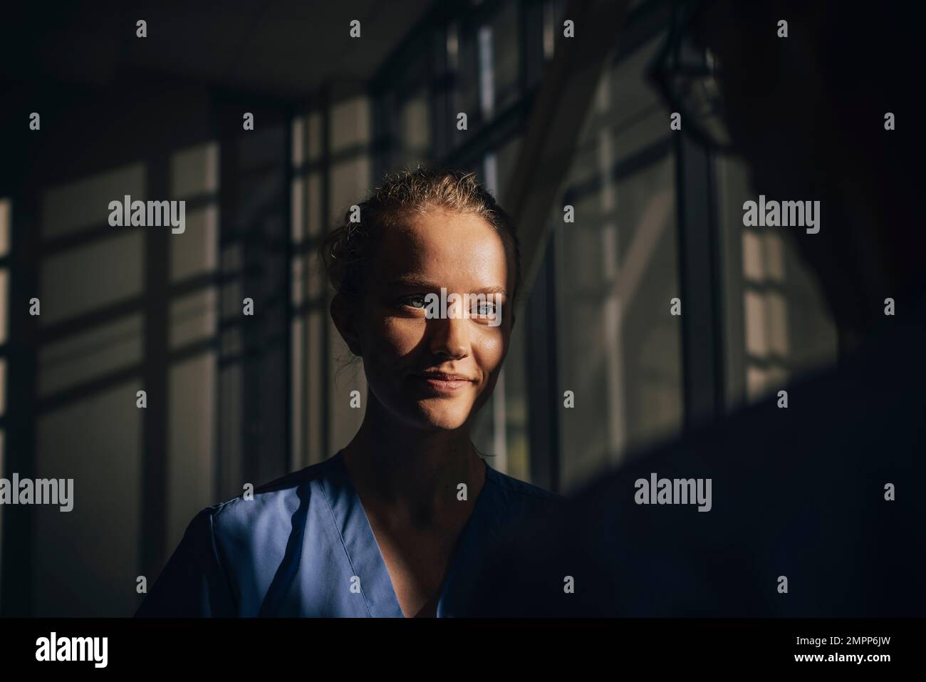Luce solare che cade di fronte a una giovane infermiera in ospedale Foto Stock