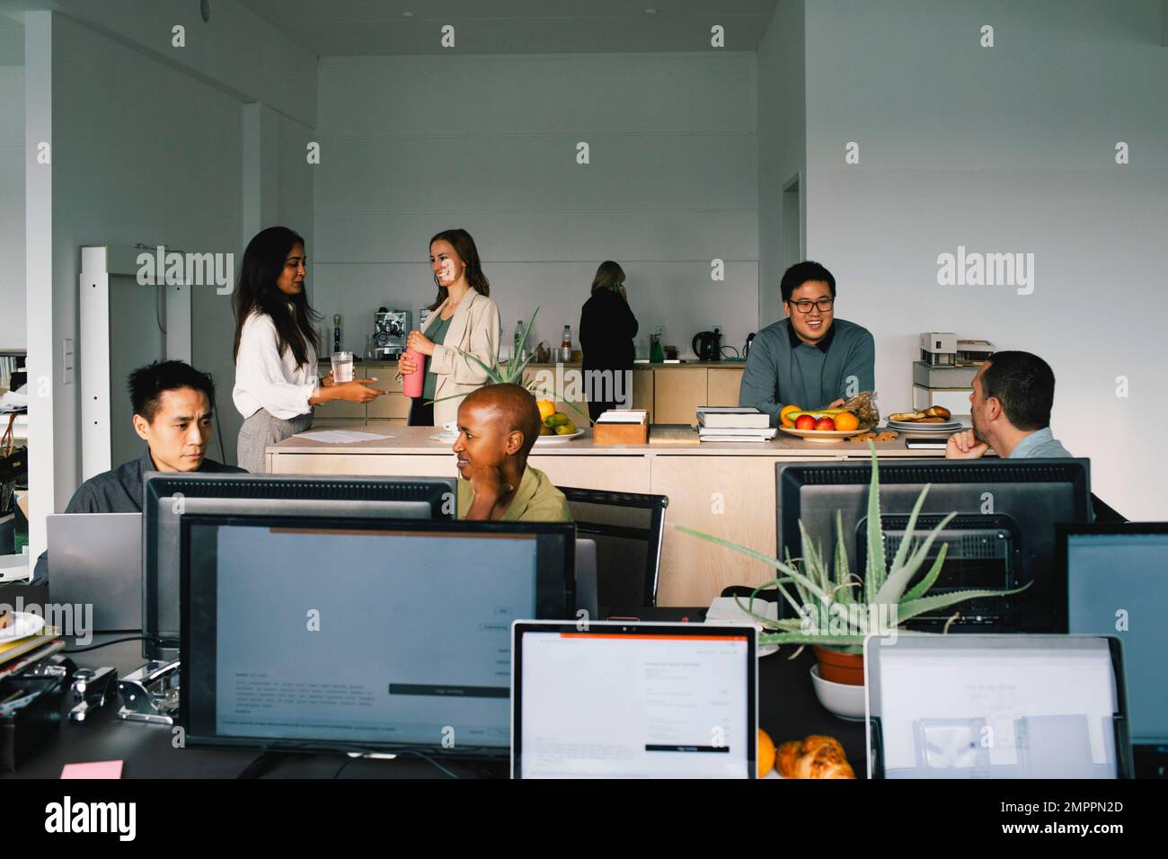 Colleghi aziendali multirazziali che comunicano tra loro in ufficio Foto Stock
