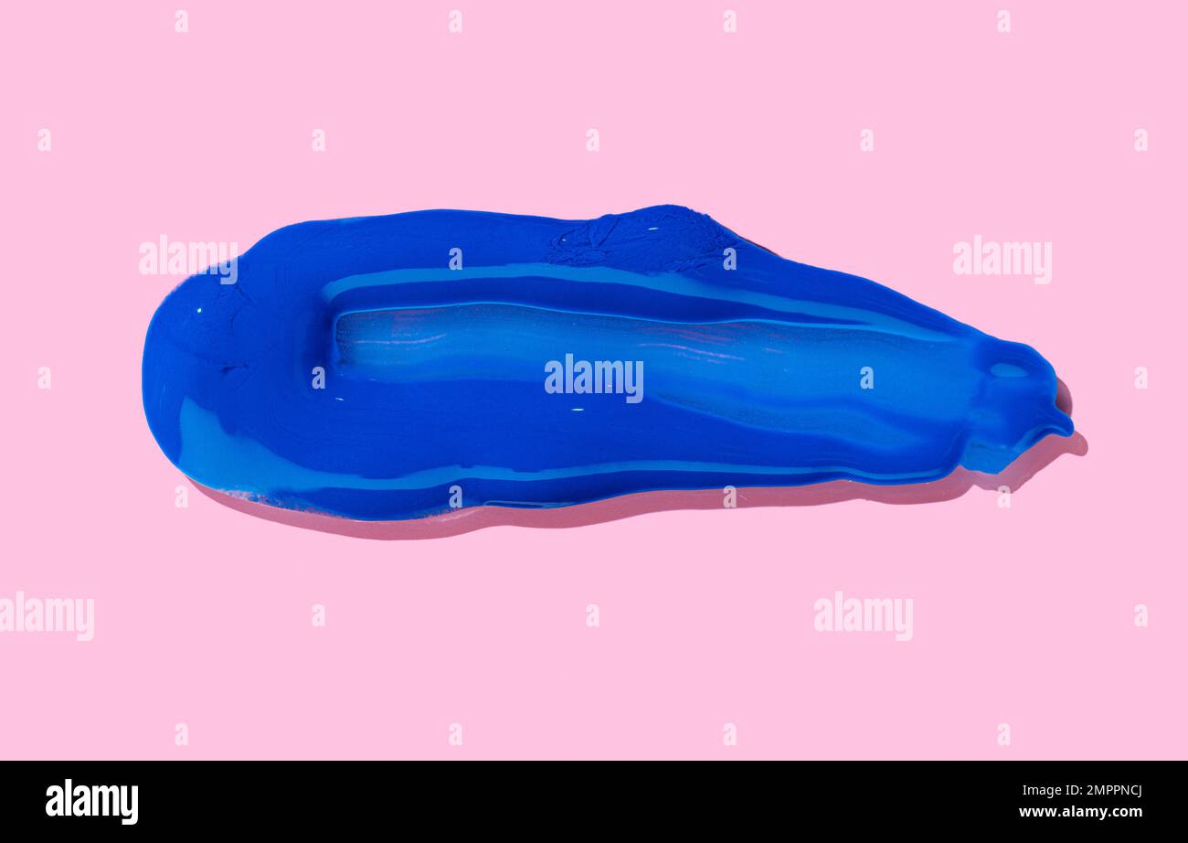 Pennello blu traccia isolata su sfondo rosa. Vernice acrilica Foto Stock