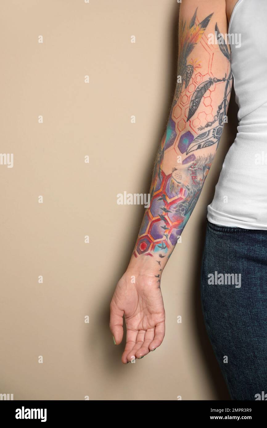 Donna con tatuaggi colorati su braccio su sfondo beige, primo piano Foto  stock - Alamy