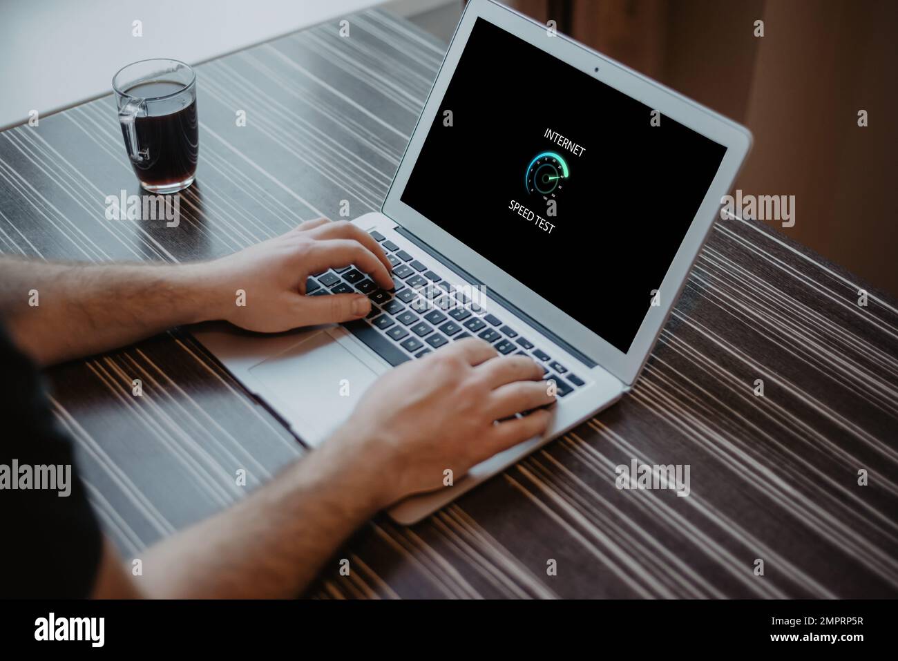 Uomo che controlla la velocità della connessione a Internet sul laptop Foto Stock