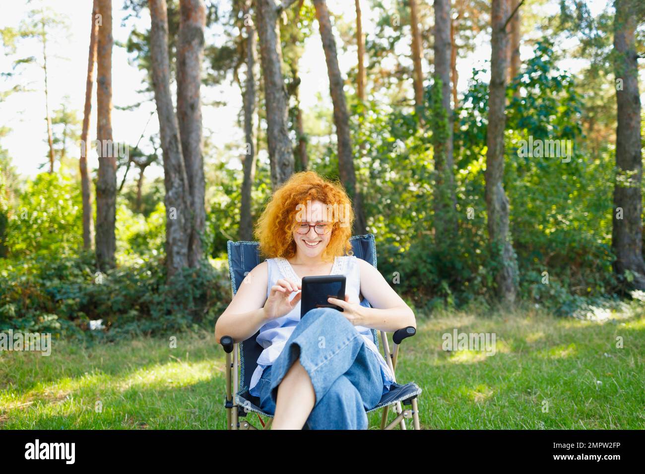 Giovane donna campeggio e lettura in natura Foto Stock