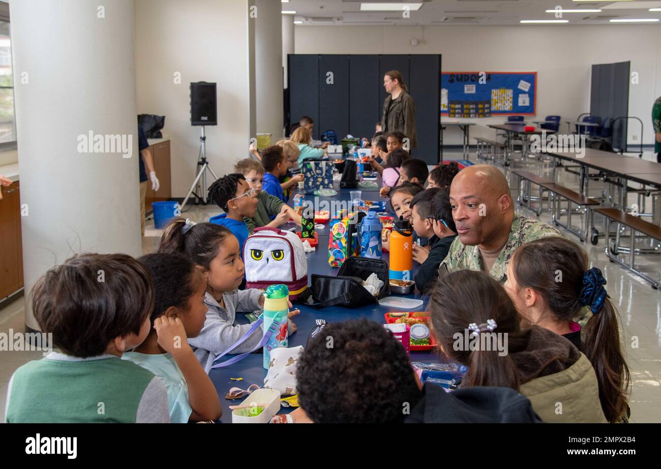 David Adams, comandante, Fleet Activities Sasebo (CFAS), mangia pranzo e parla con gli studenti della scuola elementare Jack N. Darby del 21 novembre 2022. Per 75 anni, CFAS ha fornito, mantenuto e gestito strutture e servizi di base per potenziare le forze alleate e statunitensi schierate in futuro, fornendo al contempo un supporto superiore alle loro famiglie e alla comunità. Foto Stock