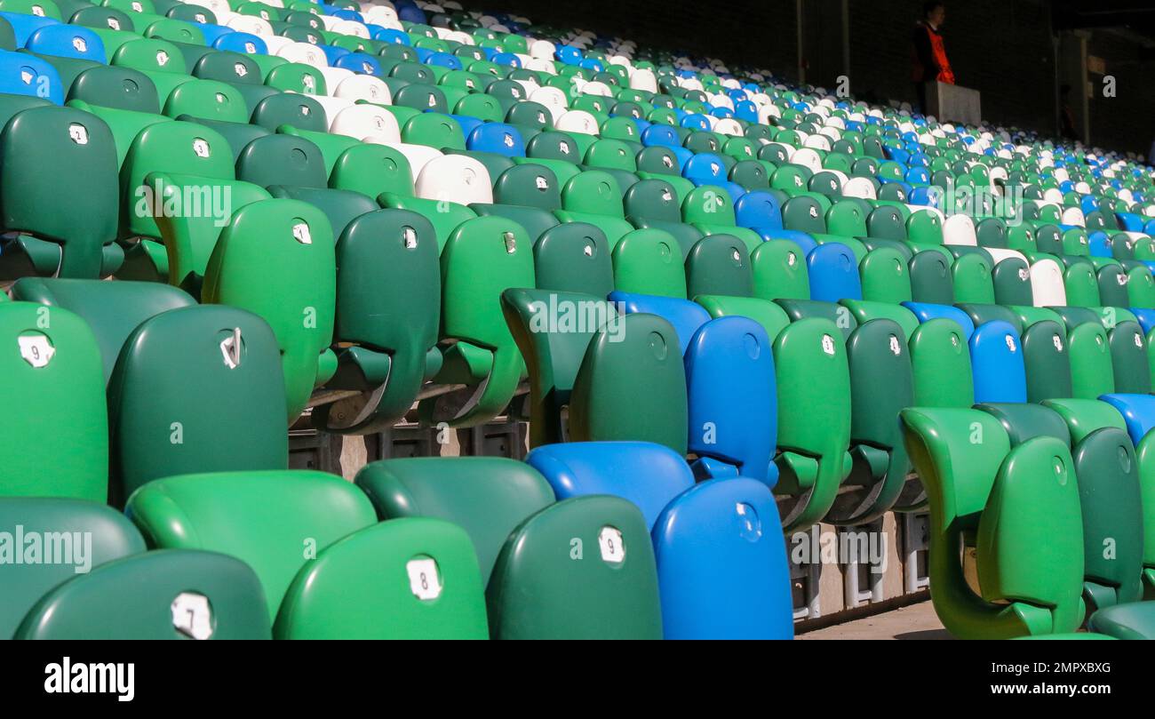 Moderno stadio di calcio del Regno Unito. File di posti a sedere ribaltabili di colore verde blu bianco nello stadio Windsor Park, Belfast. Foto Stock
