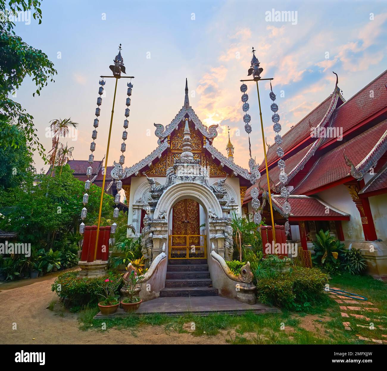 Ubosot ornato di Wat Mahawan con cancello in stucco scolpito, porte in legno e estremità a timpano, decorato con foglie dorate, tetto diviso con bargette in argento, Foto Stock