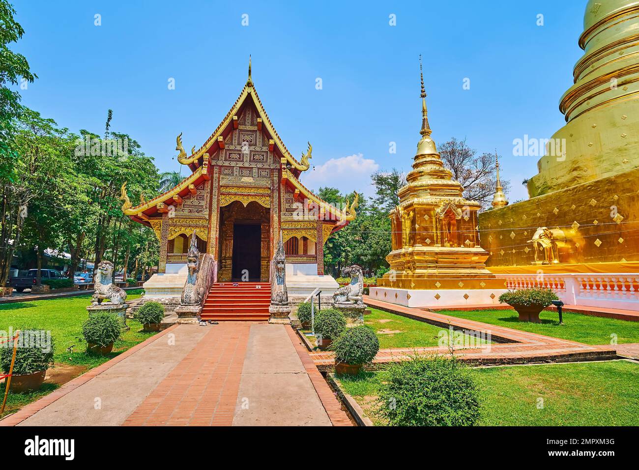 La facciata medievale in legno di stile Lanna Viharn Lai Kham e i chedis dorati di Wat Phra Singh, Chiang mai, Thailandia Foto Stock