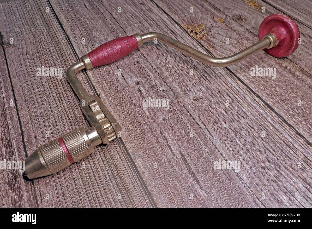trapano a mano non elettrico vecchio su un tavolo di legno Foto Stock
