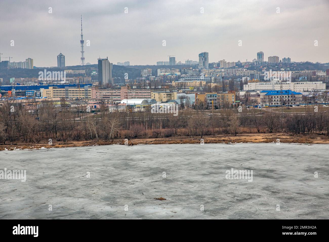 Kiev, Ucraina - 14 marzo 2021: Paesaggio urbano invernale con lago Kirillivske congelato, e quartiere residenziale di Obolon. E' una località storica che include Foto Stock